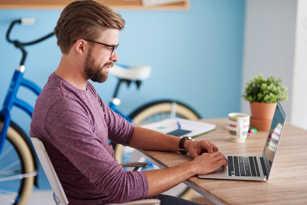 Uomo che lavora al computer portatile a casa