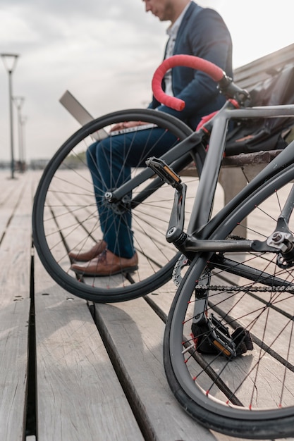 Uomo che lavora al computer portatile accanto alla sua bici