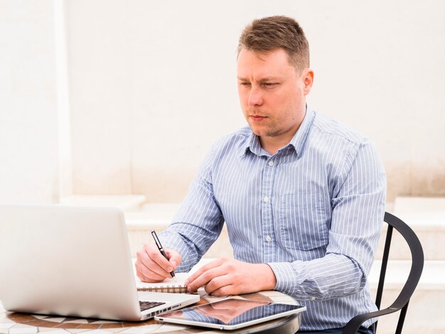 Uomo che lavora al computer portatile all'aperto