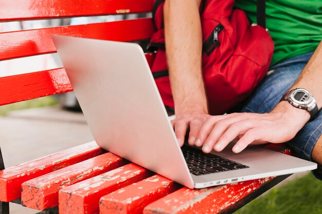 Uomo che lavora al computer portatile in panchina