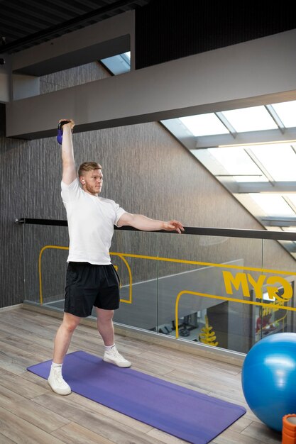 Uomo che lavora con il colpo pieno di kettlebell