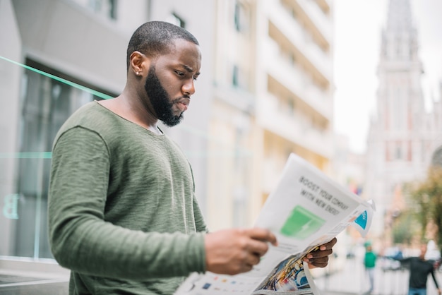 Uomo che legge il giornale in strada