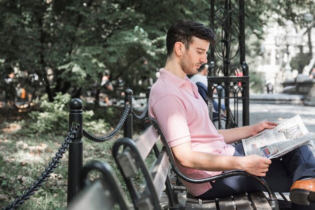 Uomo che legge il giornale sulla panchina