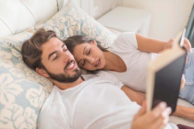 Uomo che legge il libro alla ragazza addormentata