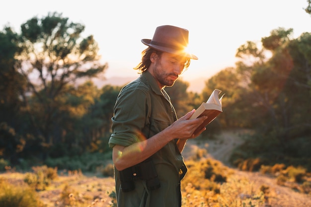 Uomo che legge il libro in campagna