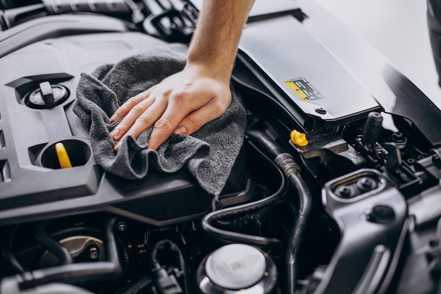 Uomo che lucida l'auto all'interno al servizio auto