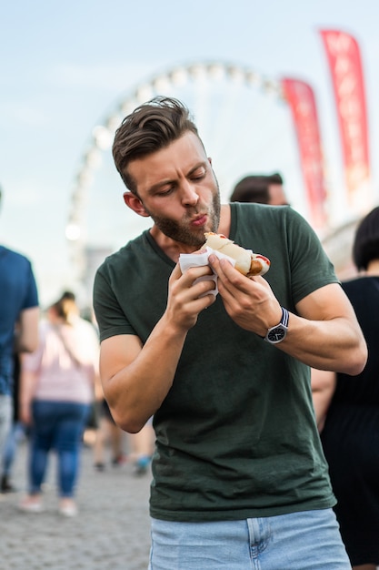 uomo che mangia cibo di strada. hot dog di strada