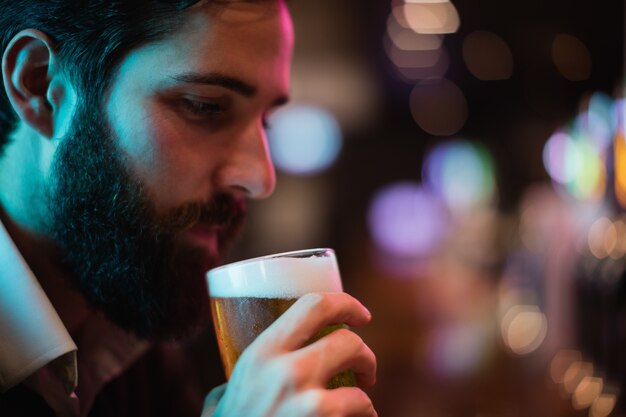 Uomo che mangia un bicchiere di birra