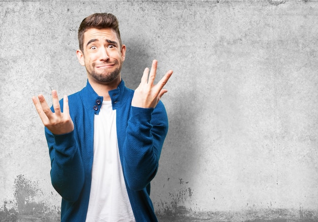 Uomo che mette su una faccia strana con le mani alzate