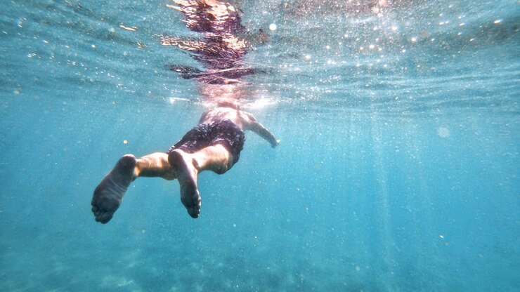 Foto gratuito uomo che nuota nell'acqua del mar mediterraneo