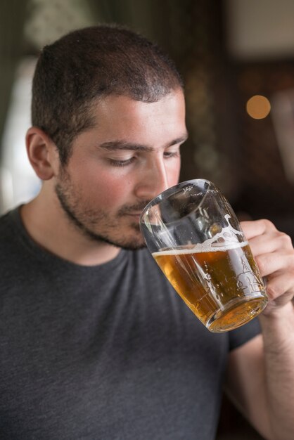 Uomo che odora la birra al bar