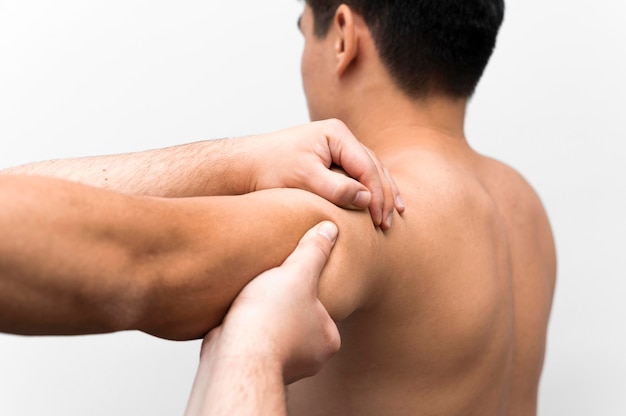 Uomo che ottiene massaggio alla spalla dal fisioterapista