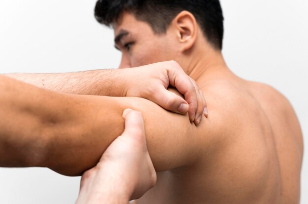 Uomo che ottiene massaggio del dolore alla spalla dal fisioterapista