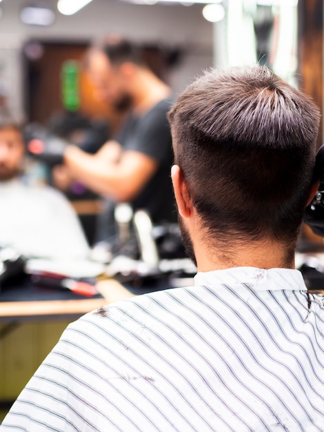 Uomo che ottiene un nuovo taglio di capelli da dietro