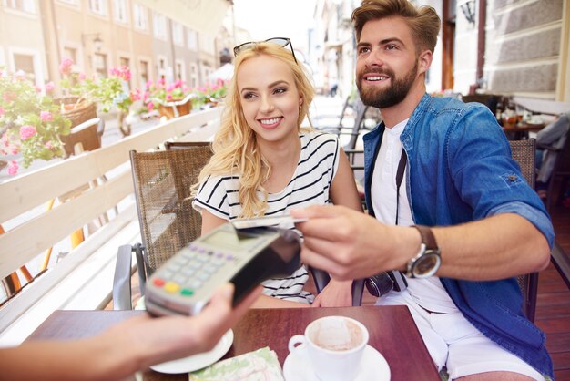 Uomo che paga il caffè con carta di credito