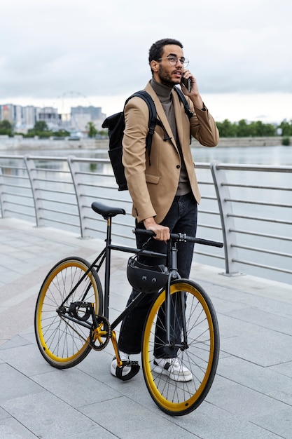 Uomo che parla al telefono mentre si tiene la bici