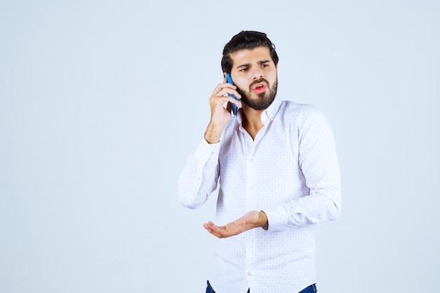 Uomo che parla con il suo nuovo modello di smartphone blu