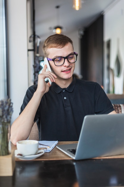 Uomo che parla per telefono al tavolo