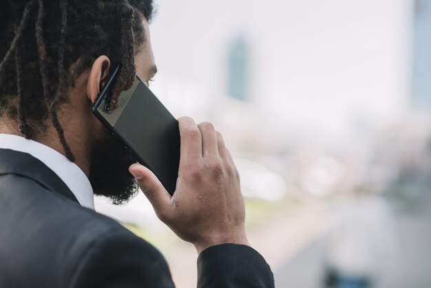 Uomo che parla sulla vista posteriore del telefono