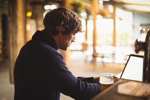 Uomo che per mezzo del computer portatile