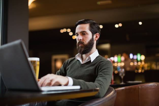 Uomo che per mezzo del computer portatile