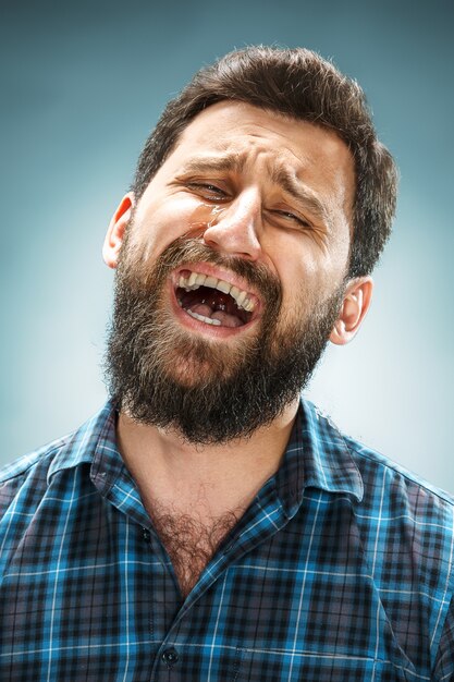 Uomo che piange in camicia blu