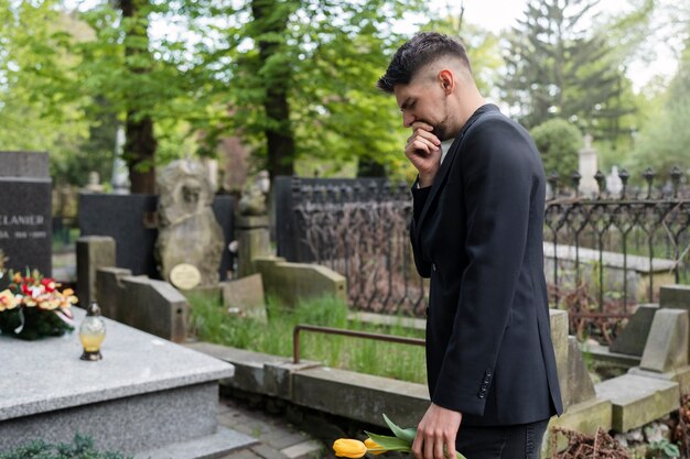 Uomo che porta i tulipani a una tomba