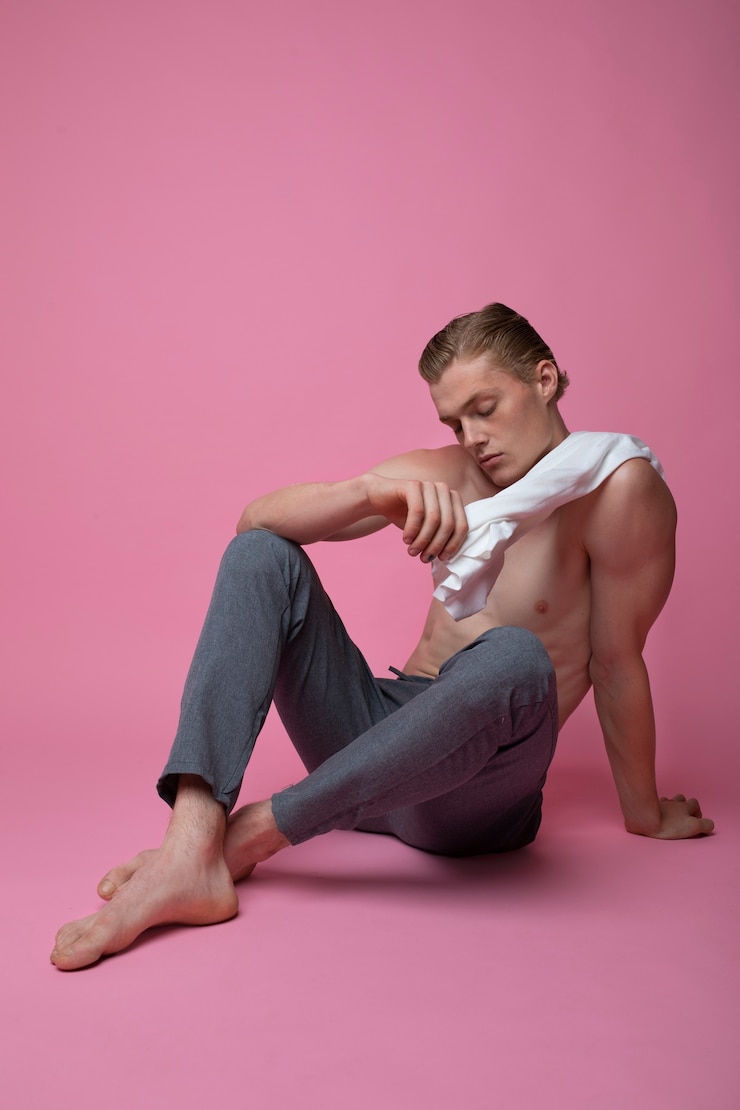 Foto gratuito uomo che posa con il colpo pieno del fondo rosa