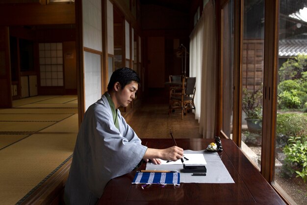 Uomo che pratica la calligrafia giapponese