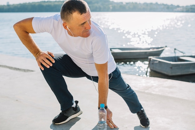 Uomo che pratica sport vicino a un lago