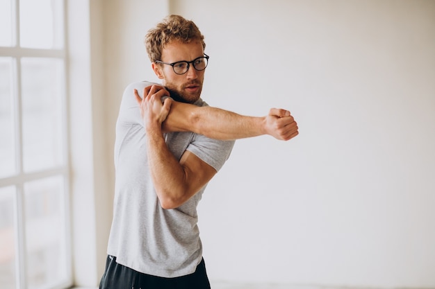 Uomo che pratica yoga sul tappetino a casa