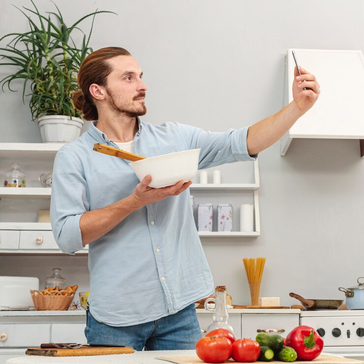 Foto gratuito uomo che prende un selfie con una ciotola della cucina