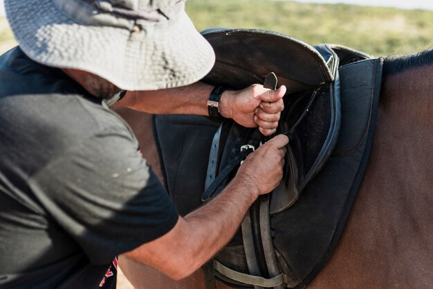 Uomo che prepara il cavallo per il giro