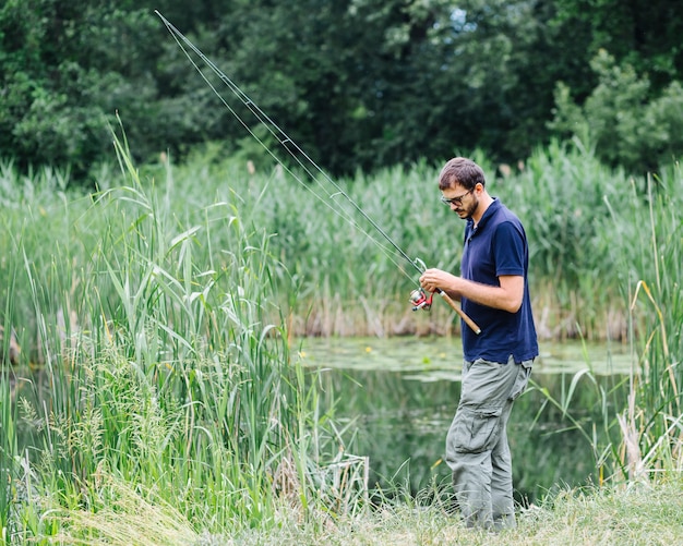 Uomo che prepara la canna da pesca per catturare il pesce