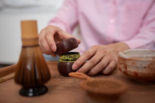 Uomo che prepara la vista frontale del tè matcha