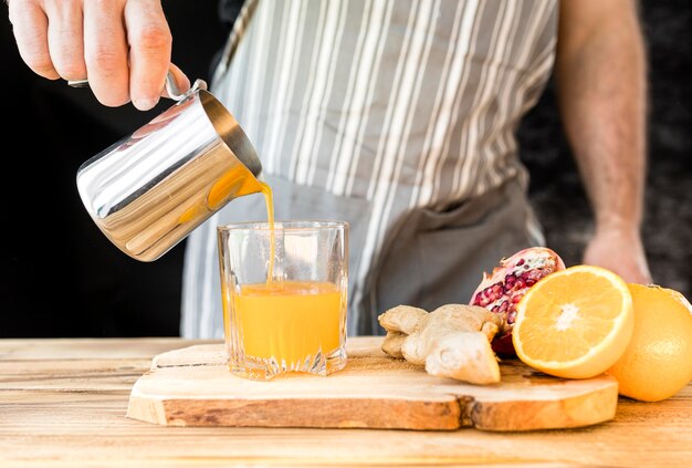 Uomo che produce una vista frontale del succo d'arancia