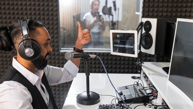 Uomo che registra una donna che canta in una stazione radio