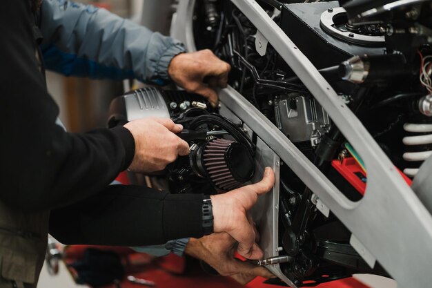 Uomo che ripara una moto in una moderna officina