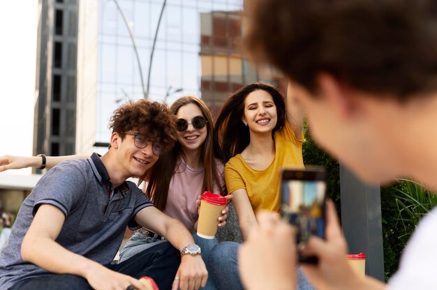 Uomo che scatta foto dei suoi amici mentre è all'aperto