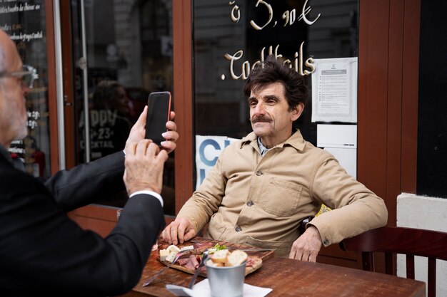 Uomo che scatta foto di un amico anziano