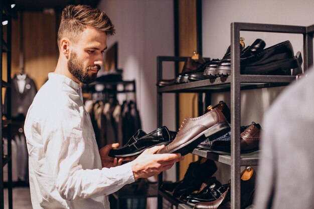 Uomo che sceglie l'usura del piede al negozio di mens