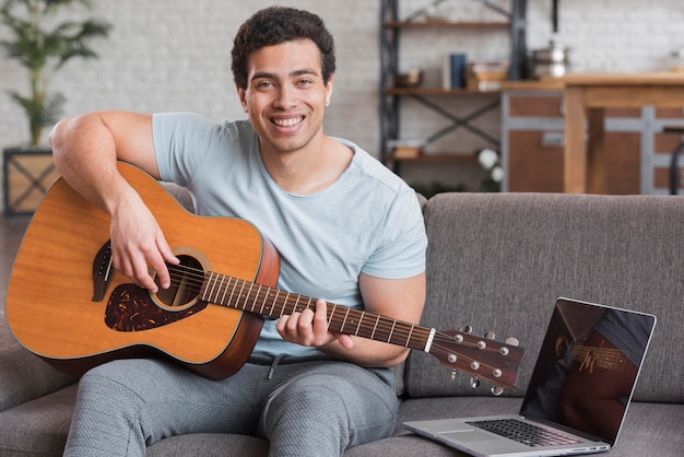 Uomo che segue corsi online per suonare la chitarra