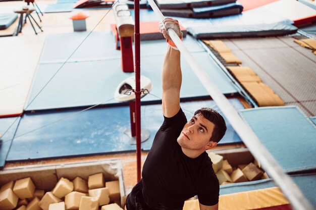 Uomo che si allena con barre parallele per campionato di ginnastica