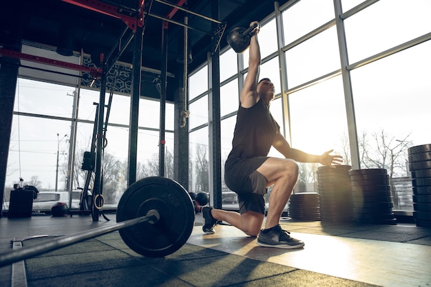 Uomo che si allena con i manubri in palestra