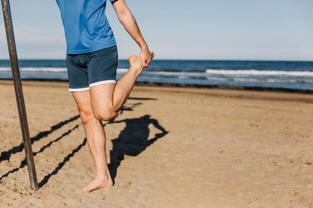 Uomo che si estende in spiaggia