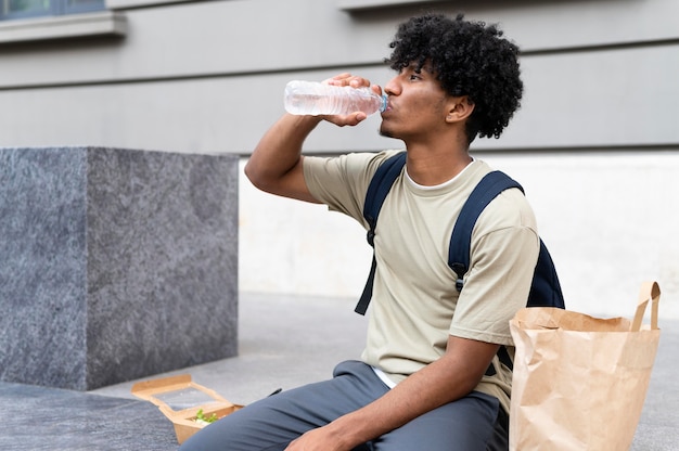 Uomo che si gode del cibo da asporto all'aperto