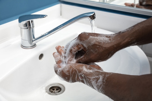 Uomo che si lava accuratamente le mani con sapone e disinfettante, primo piano. Prevenzione della diffusione del virus della polmonite, protezione contro la pandemia di coronavirus. Igiene, sanitario, pulizia, disinfezione. Sicurezza.