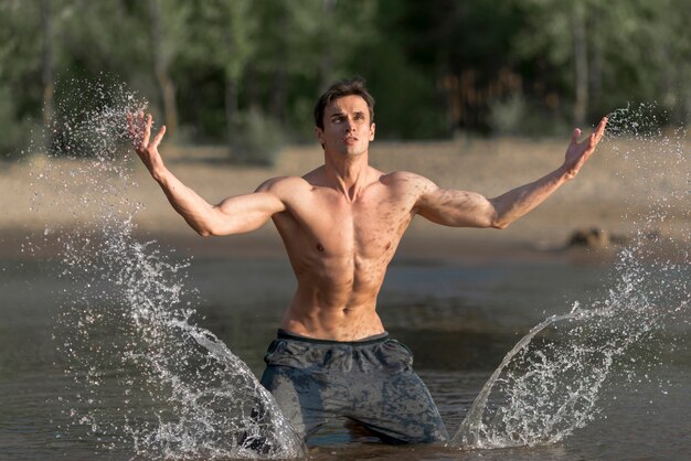 Uomo che spruzza acqua in spiaggia