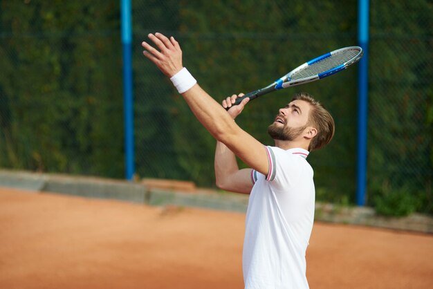 Uomo che sta per servire una pallina da tennis