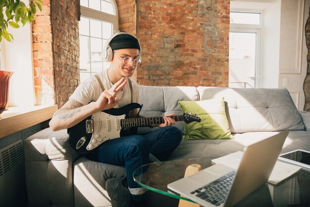 Uomo che studia a casa durante i corsi online di musica.